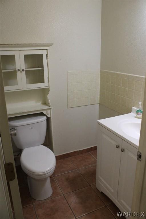 half bath with vanity, toilet, and tile patterned floors