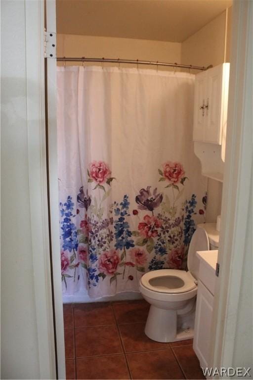 bathroom with tile patterned flooring, shower / tub combo with curtain, vanity, and toilet