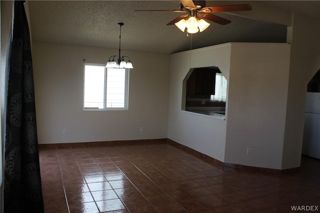 spare room with dark tile patterned floors, a textured ceiling, baseboards, and ceiling fan with notable chandelier