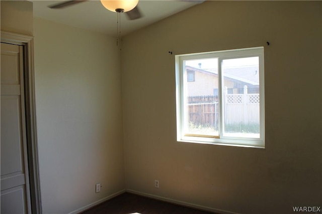 unfurnished room featuring ceiling fan and baseboards