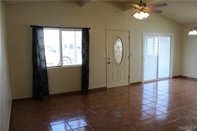 entrance foyer featuring lofted ceiling, baseboards, a ceiling fan, and dark tile patterned flooring