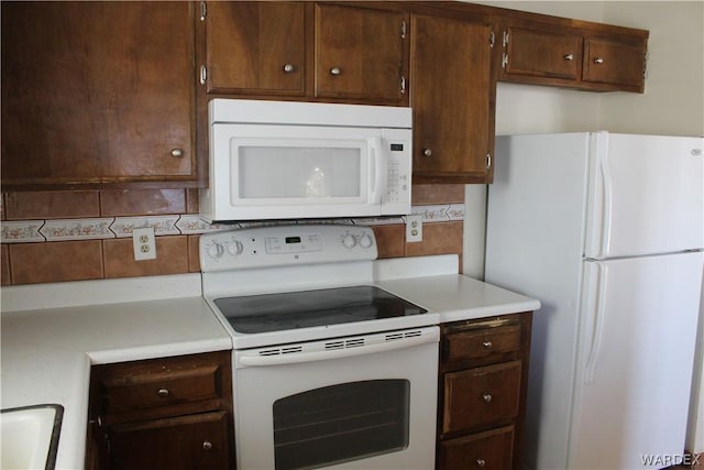 kitchen featuring white appliances, tasteful backsplash, and light countertops