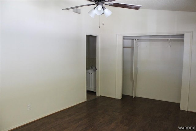 unfurnished bedroom featuring dark wood-style floors, a closet, visible vents, and a ceiling fan