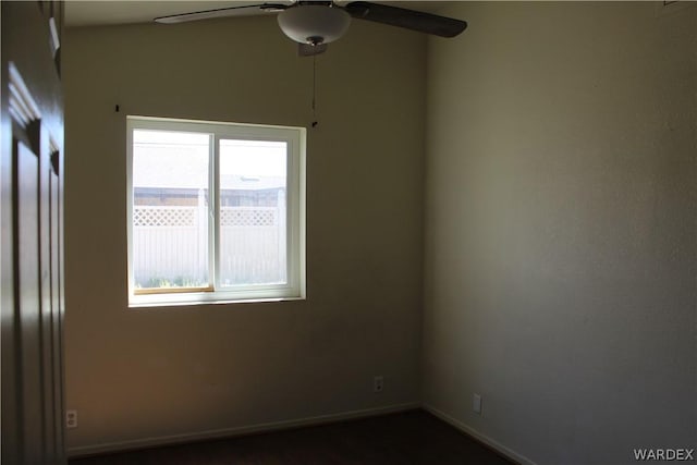 spare room featuring baseboards and a ceiling fan