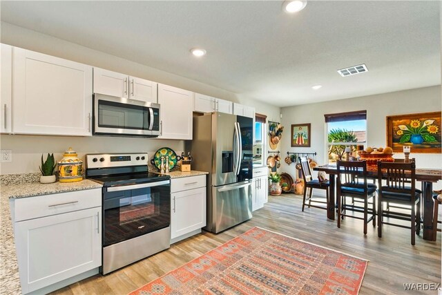 kitchen with light wood finished floors, visible vents, appliances with stainless steel finishes, white cabinetry, and recessed lighting