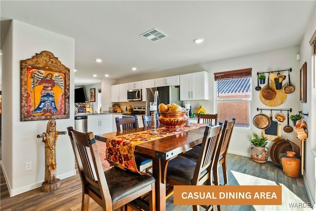 dining area featuring baseboards, visible vents, dark wood finished floors, and recessed lighting