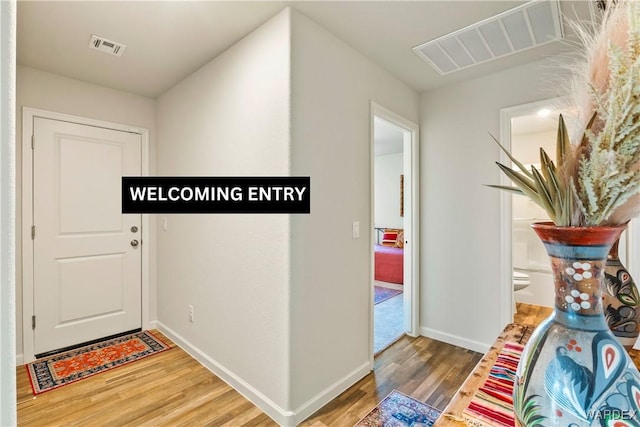 entrance foyer with visible vents, baseboards, and wood finished floors