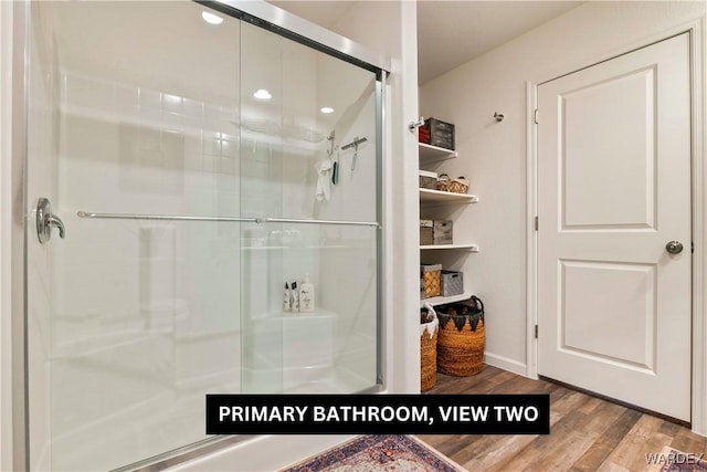 full bath featuring a stall shower and wood finished floors