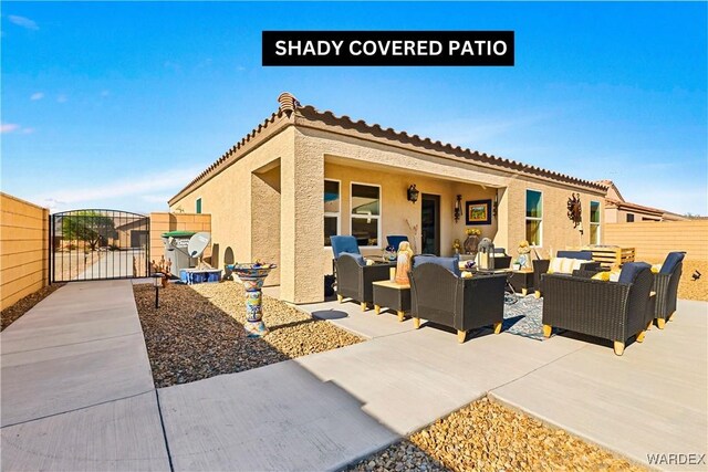 view of patio with a gate, an outdoor living space, and fence