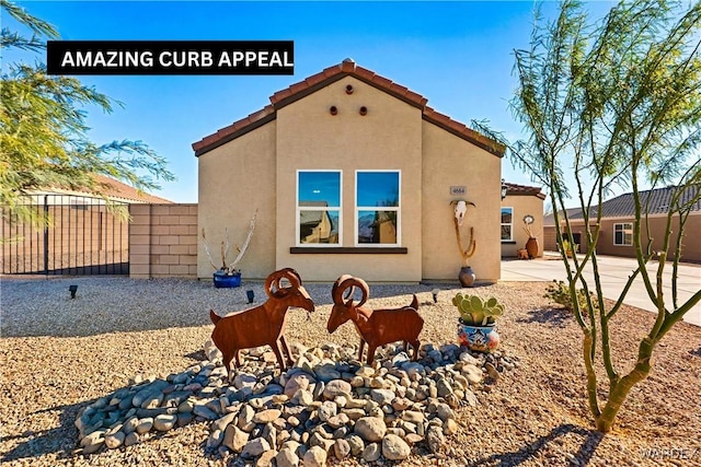 back of property featuring a tiled roof, fence, a patio, and stucco siding