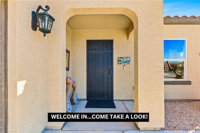 entrance to property featuring stucco siding