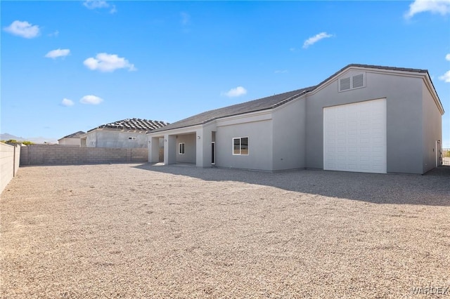 back of house featuring fence and stucco siding