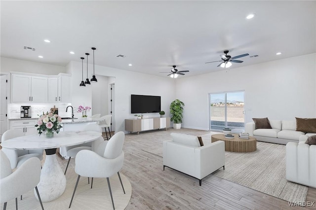 living area featuring light wood-style floors, visible vents, and recessed lighting