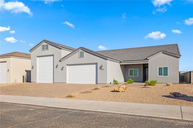 ranch-style house featuring a garage, driveway, and stucco siding