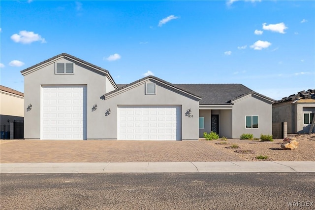 single story home featuring a garage, driveway, and stucco siding