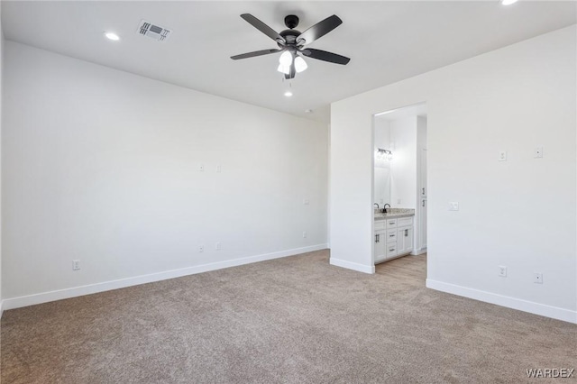 unfurnished bedroom with recessed lighting, visible vents, light carpet, a sink, and baseboards