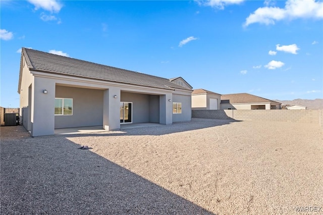 back of property featuring a patio, cooling unit, a garage, fence, and stucco siding