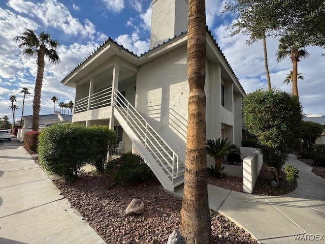 view of property exterior featuring stairway and stucco siding