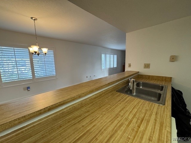 kitchen featuring a chandelier, pendant lighting, and a sink