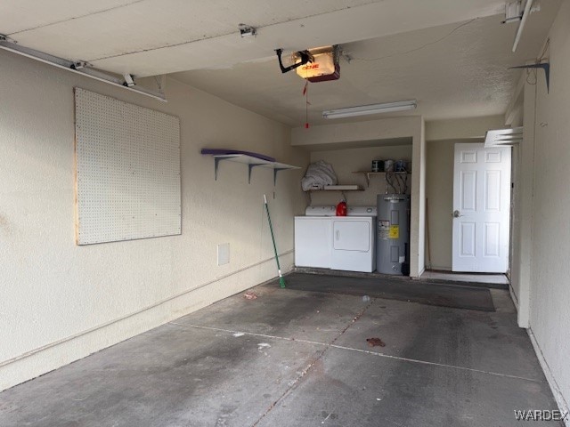 garage with a garage door opener, electric water heater, and independent washer and dryer