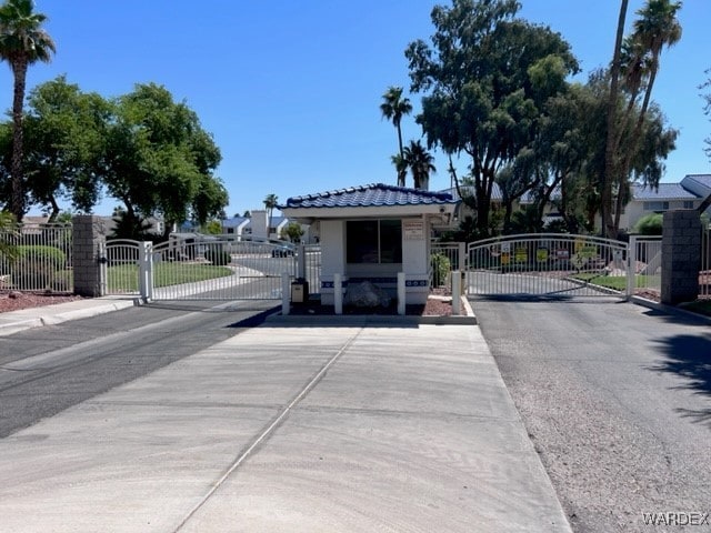 view of street with a gate, curbs, and a gated entry