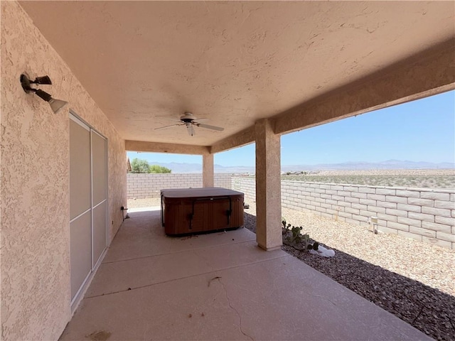 2217 E Emerald River Way, Fort Mohave, AZ 86426 - fenced backyard featuring a hot tub, a patio area, ceiling fan, and a mountain view