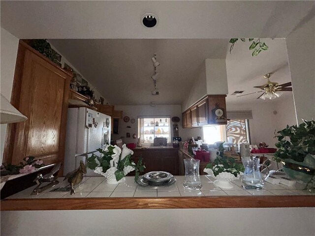 2217 E Emerald River Way, Fort Mohave, AZ 86426 - kitchen with white refrigerator with ice dispenser, tile countertops, rail lighting, and brown cabinets