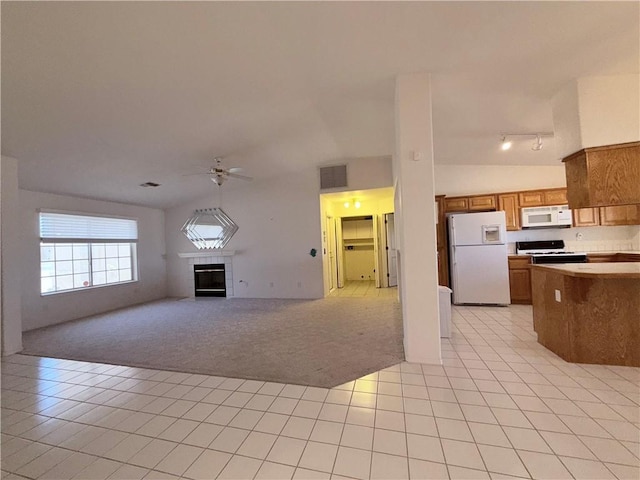 2217 E Emerald River Way, Fort Mohave, AZ 86426 - kitchen featuring white appliances, light tile patterned floors, ceiling fan, a tiled fireplace, and open floor plan