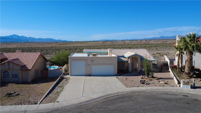 2217 E Emerald River Way, Fort Mohave, AZ 86426 - view of front of property with stucco siding, a chimney, a garage, a mountain view, and concrete driveway