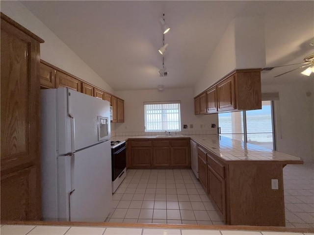 2217 E Emerald River Way, Fort Mohave, AZ 86426 - kitchen with white appliances, a peninsula, vaulted ceiling, light tile patterned floors, and rail lighting
