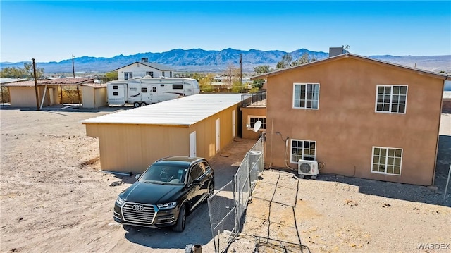 view of front of home with ac unit, a mountain view, an outdoor structure, and stucco siding