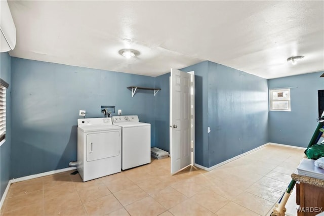 laundry room with laundry area, baseboards, light tile patterned flooring, and washing machine and clothes dryer