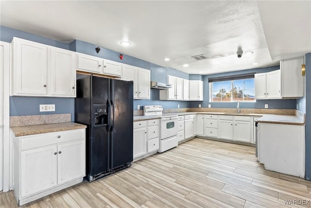 kitchen featuring visible vents, white cabinets, electric stove, black fridge, and light wood-type flooring