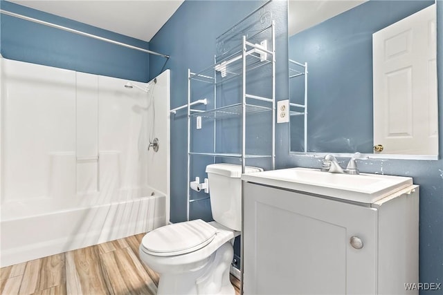 bathroom featuring shower / washtub combination, vanity, toilet, and wood finished floors