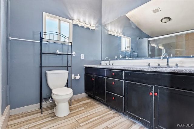 full bath featuring toilet, wood finished floors, a sink, and visible vents