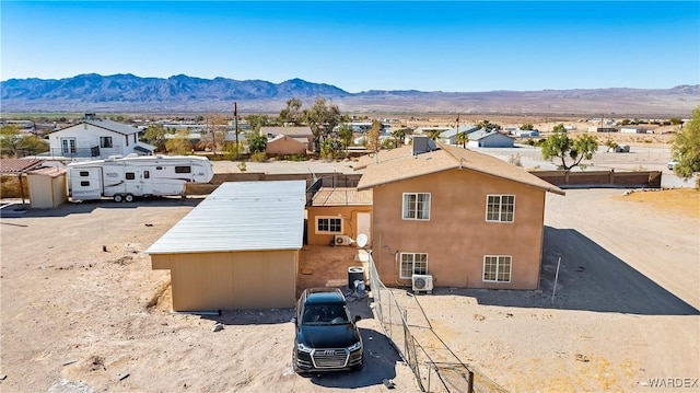 exterior space with an outbuilding, a mountain view, stucco siding, a shed, and ac unit