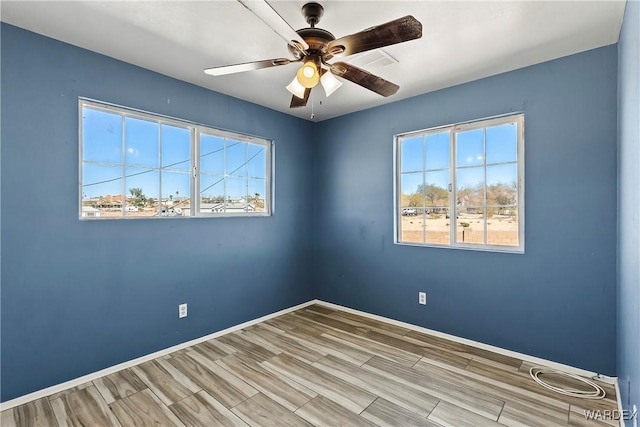 spare room with ceiling fan, baseboards, and wood finish floors