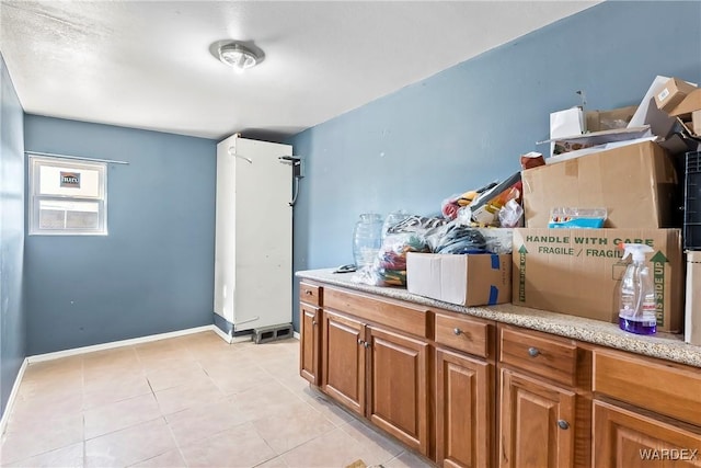 interior space featuring baseboards and light tile patterned flooring