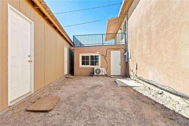 exterior space with ac unit, a balcony, and stucco siding