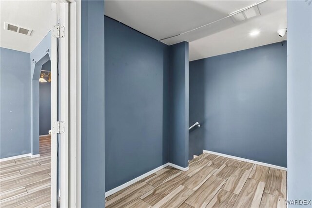 interior space with wood finish floors, visible vents, and baseboards