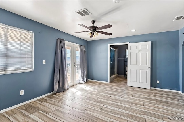 empty room with wood tiled floor, visible vents, baseboards, and french doors