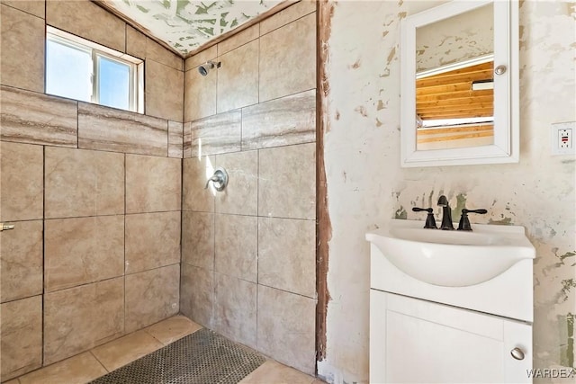 bathroom with tiled shower and vanity