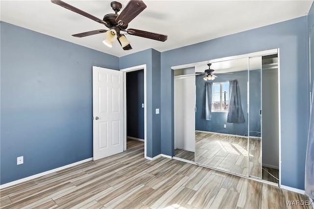 unfurnished bedroom featuring ceiling fan, wood finish floors, a closet, and baseboards