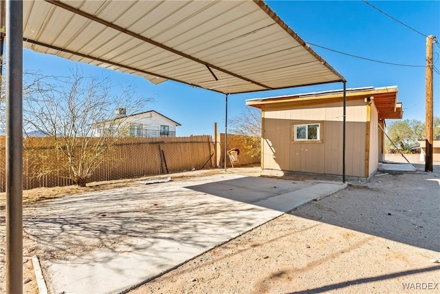 view of patio featuring an outbuilding and fence