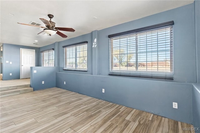 unfurnished room featuring a ceiling fan, visible vents, and wood finished floors