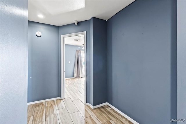 hall with baseboards and wood finish floors