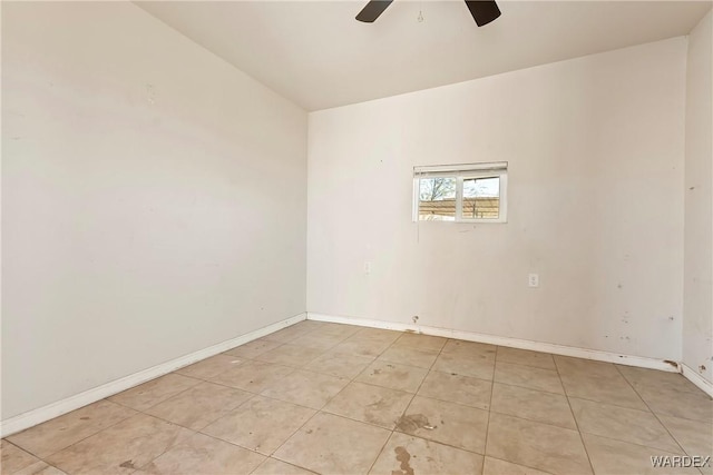 spare room with a ceiling fan and baseboards