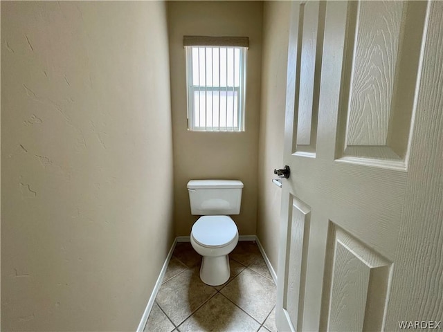 bathroom featuring tile patterned flooring, toilet, and baseboards