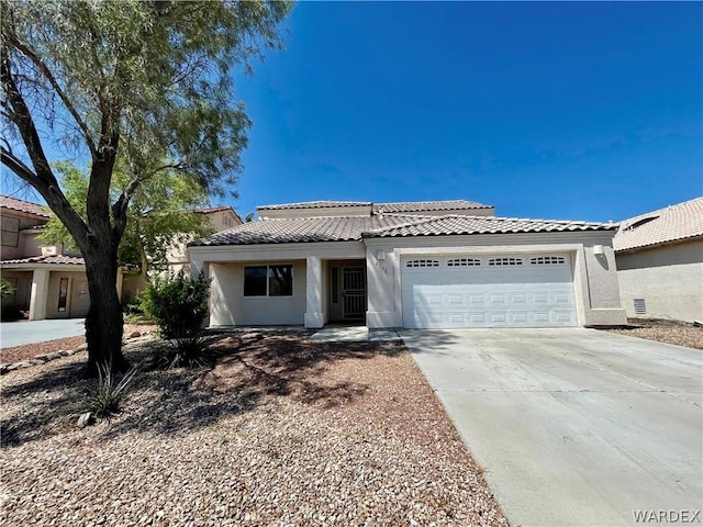 view of front facade with driveway, an attached garage, a tile roof, and stucco siding