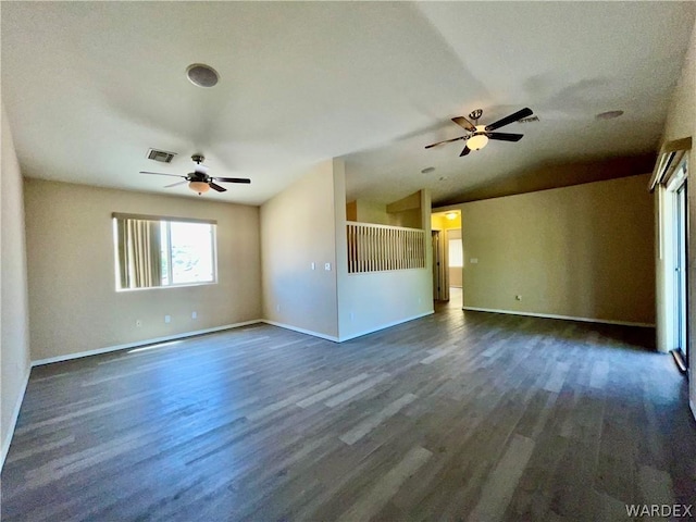 spare room featuring visible vents, baseboards, lofted ceiling, dark wood-style floors, and ceiling fan